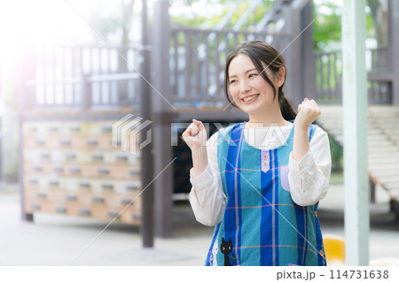 園庭で頑張って働く保育士 ガッツポーズでやる気のあるイメージ 園庭で頑張って働く保育士 ガッツポーズでやる気のあるイメージ 114731638