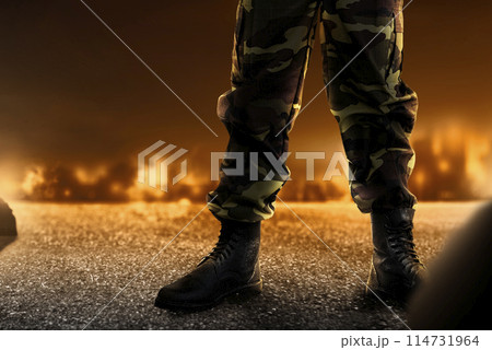 Soldier feet with military boots standing with fire and explosion 114731964