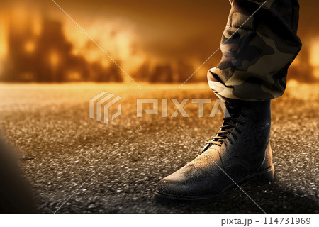 Soldier feet with military boots standing with fire and explosion Soldier feet with military boots standing with fire and explosion 114731969