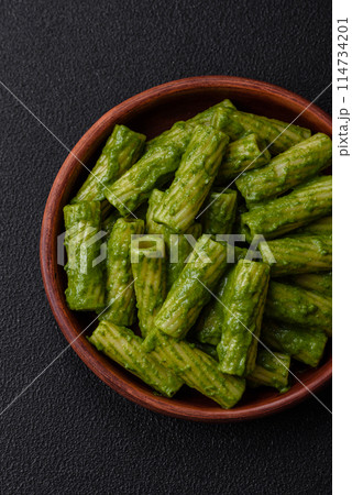 Delicious pasta with spinach sauce, olive oil and parmesan cheese Delicious pasta with spinach sauce, olive oil and parmesan cheese 114734201