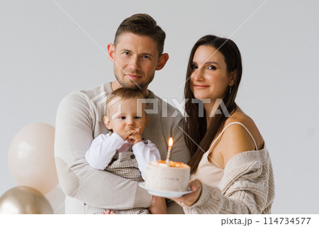 Happy parents mom and dad with their son celebrate birthday with cake and balloons Happy parents mom and dad with their son celebrate birthday with cake and balloons 114734577
