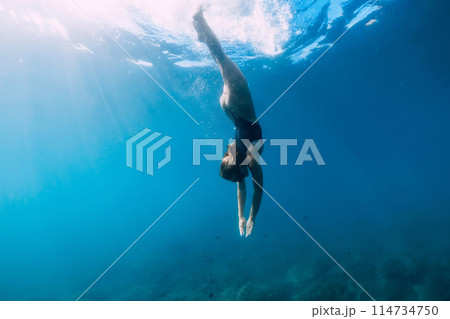Woman swims in clear sea. Freediving and beautiful lady in ocean Woman swims in clear sea. Freediving and beautiful lady in ocean 114734750