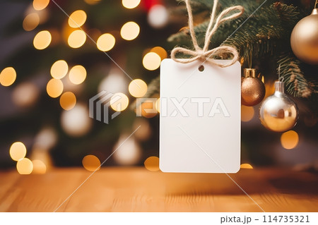 Blank price tag hanging on christmas tree with bokeh background	 114735321