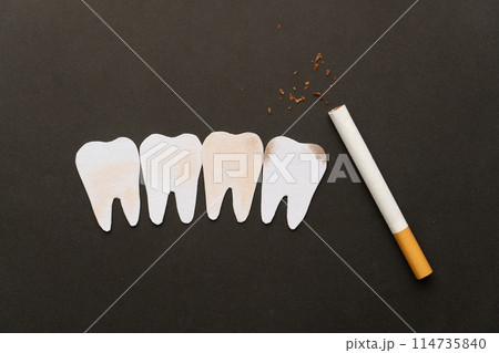 Cigarettes or tobacco with tooth shape on black background. Teeth problems caused by smoking include staining, gum disease and cavities. World no tobacco day concept template. 114735840