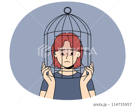Unhappy teen girl with head in birdcage 114735957