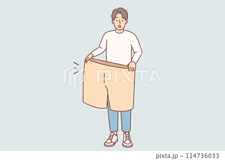 Lost weight man with big shorts in hands is surprised at size of own clothes from past 114736033