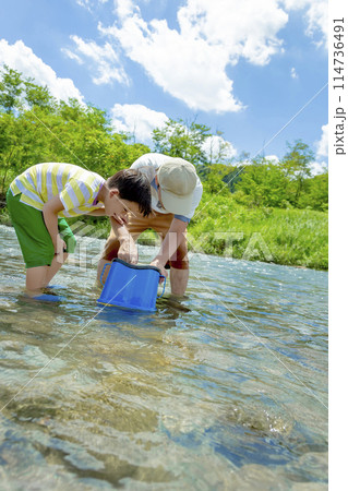 水中のぞきメガネで川遊びをする父親と息子 114736491