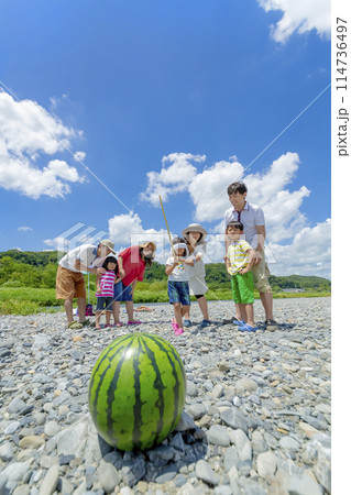 川原でスイカ割りをする家族連れ 114736497