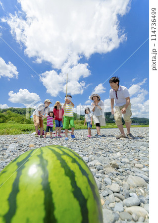 川原でスイカ割りをする家族連れ 川原でスイカ割りをする家族連れ 114736499