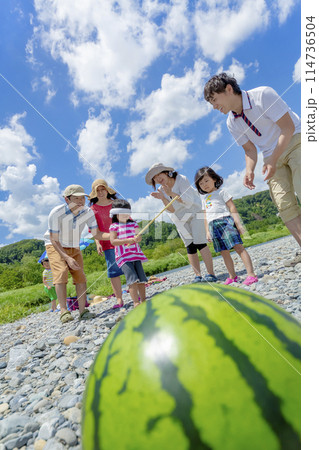 川原でスイカ割りをする家族連れ 川原でスイカ割りをする家族連れ 114736504