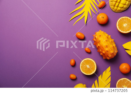Tropical fruit and paper leaves on purple background, space for text 114737205