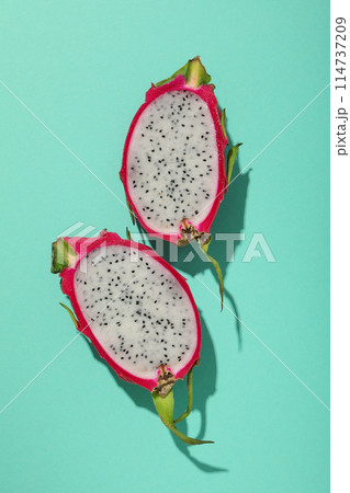 Two half of dragon fruit on blue background, top view Two half of dragon fruit on blue background, top view 114737209
