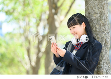 スマホを持つ女子高生 ヘッドフォン スマホを持つ女子高生 ヘッドフォン 114739336