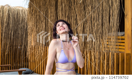 Woman in blue bikini relaxing in Turkish resort while basking on the beach 114739702