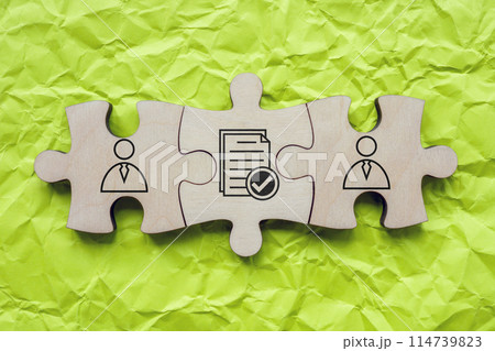Puzzle elements with figures and a contract as a symbol of understanding and agreement. 114739823