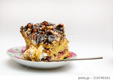 Piece of cake with hazelnuts and chocolate in a saucer 114740161