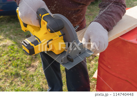 Man sawing board with a circular saw. High quality photo 114740448