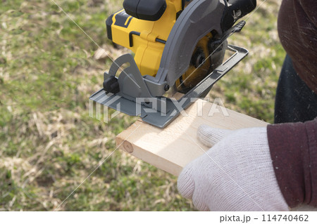 Man sawing board with a circular saw. High quality photo 114740462
