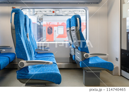 Inside The Wagon Train. Interior of the passenger train with empty blue fabric seats. High quality photo 114740465