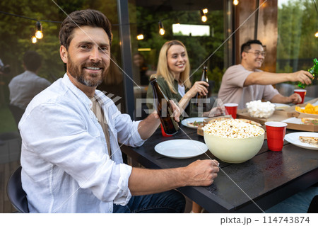 Young people enjoying leisure time together outside toasting with beer Young people enjoying leisure time together outside toasting with beer 114743874