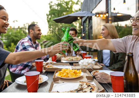 Young people enjoying leisure time together outside toasting with beer 114743885