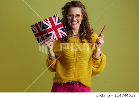 smiling trendy woman in sweater and glasses against green smiling trendy woman in sweater and glasses against green 114744618