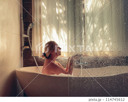 Middle aged woman taking a bath Middle aged woman taking a bath 114745612