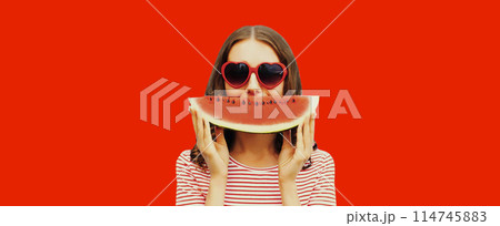 Summer portrait of happy young woman with slice of watermelon wearing red heart shaped sunglasses Summer portrait of happy young woman with slice of watermelon wearing red heart shaped sunglasses 114745883