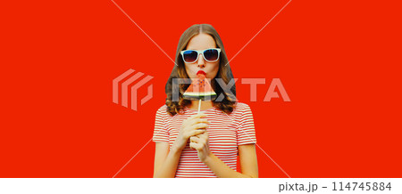 Summer portrait of stylish young woman with juicy lollipop or ice cream shaped slice of watermelon Summer portrait of stylish young woman with juicy lollipop or ice cream shaped slice of watermelon 114745884