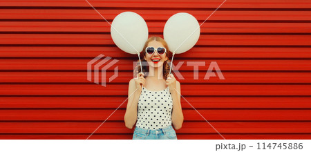 Summer, holiday, celebration, happy cheerful young woman with bright colorful balloons on red Summer, holiday, celebration, happy cheerful young woman with bright colorful balloons on red 114745886