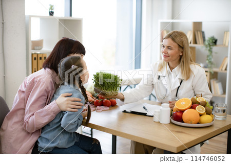 Beautiful female doctor holding microgreen while adding it to patients diet. 114746052