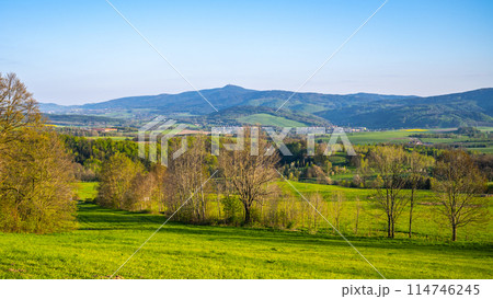 A breathtaking view of the Jested Ridge horizon, captured from a lush green field under a clear blue sky. The serene atmosphere suggests early morning or late afternoon. Located in Czech Republic 114746245