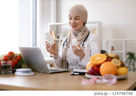 Muslim doctor in hijab distantly describes the treatment plan. Muslim doctor in hijab distantly describes the treatment plan. 114746748