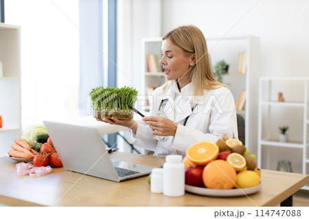 Smiling Caucasian woman introducing microgreens during online conversatio Smiling Caucasian woman introducing microgreens during online conversatio 114747088