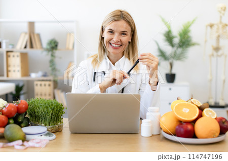 Dietitian working with laptop computer making balanced corrective diet plan. Dietitian working with laptop computer making balanced corrective diet plan. 114747196