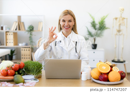 Mature nutritionist doctor with fruits in office. 114747207