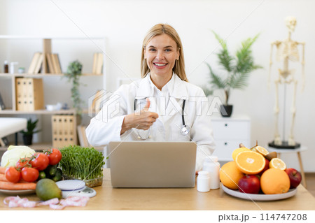 Mature nutritionist doctor with fruits in office. 114747208