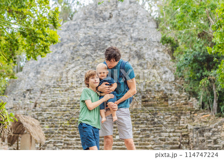 Dad with two sons tourists at Coba, Mexico. Ancient mayan city in Mexico. Coba is an archaeological area and a famous landmark of Yucatan Peninsula. Cloudy sky over a pyramid in Mexico Dad with two sons tourists at Coba, Mexico. Ancient mayan city in Mexico. Coba is an archaeological area and a famous landmark of Yucatan Peninsula. Cloudy sky over a pyramid in Mexico 114747224