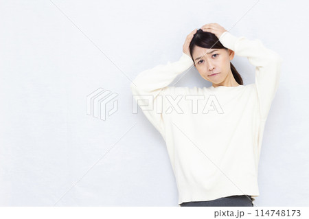 頭を抱えて悩む女性 頭を抱えて悩む女性 114748173