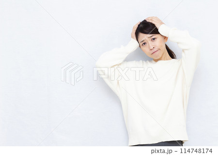 頭を抱えて悩む女性 114748174