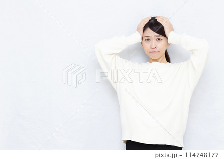 頭を抱えて悩む女性 114748177