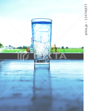 The ice glass was filled with steam and reflected on the table. The ice glass was filled with steam and reflected on the table. 114748877