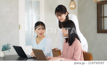 オフィスで会話するカジュアルウェアの女性グループ オフィスで会話するカジュアルウェアの女性グループ 114750597