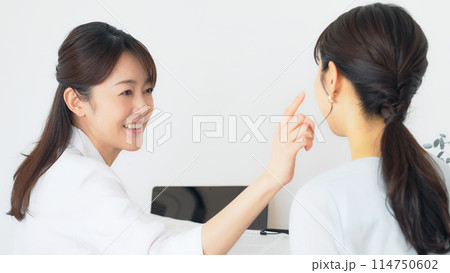 患者を診察する女性医師 患者を診察する女性医師 114750602