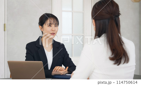 オフィスで会話する二人の女性 114750614