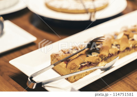 お皿に並んだケーキとトング お皿に並んだケーキとトング 114751581