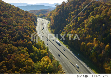 View from above of I-40 freeway route in North Carolina leading to Asheville thru Appalachian mountains with yellow fall woods and fast moving trucks and cars. Interstate transportation concept View from above of I-40 freeway route in North Carolina leading to Asheville thru Appalachian mountains with yellow fall woods and fast moving trucks and cars. Interstate transportation concept 114751769