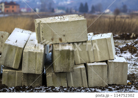 Stack of concrete blocks for foundation on construction site. Ferroconcrete reinforced with metal blocks Stack of concrete blocks for foundation on construction site. Ferroconcrete reinforced with metal blocks 114752302