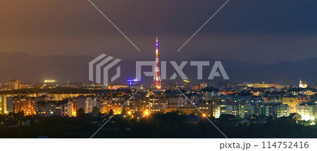 Wide panorama, aerial night view of modern tourist Ivano-Frankivsk city, Ukraine. Scene of bright lights of tall buildings, high television tower and green suburbs on Carpathian mountains background. Wide panorama, aerial night view of modern tourist Ivano-Frankivsk city, Ukraine. Scene of bright lights of tall buildings, high television tower and green suburbs on Carpathian mountains background. 114752416