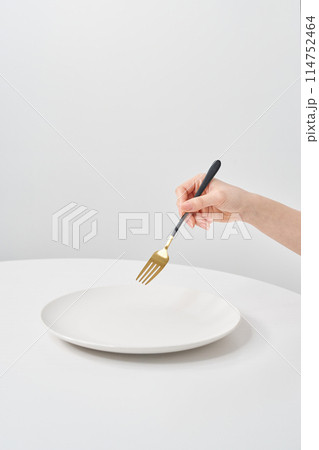 白いお皿と、フォークを持つ女性の手元 白いお皿と、フォークを持つ女性の手元 114752464